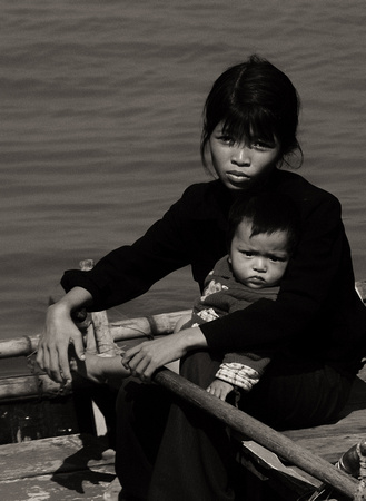 young mother and child begging from a skiff