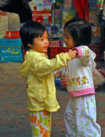 Two girls dancing on the sidewalk, Hanoi